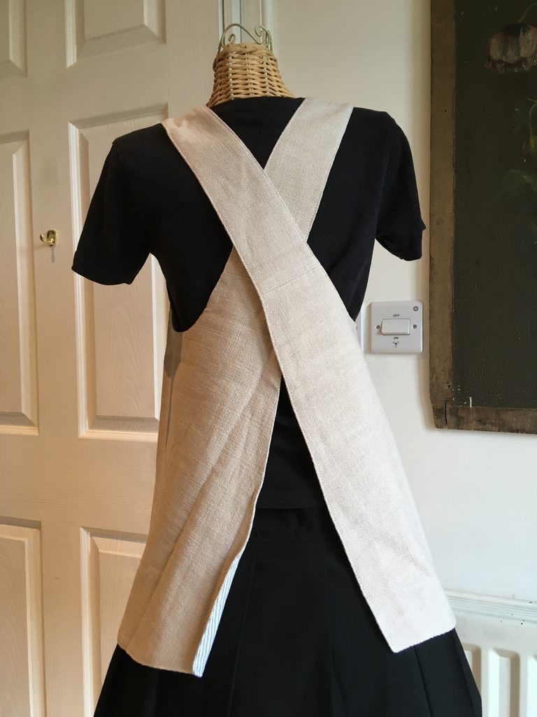 Rear view of stone-coloured tot-sized pinny