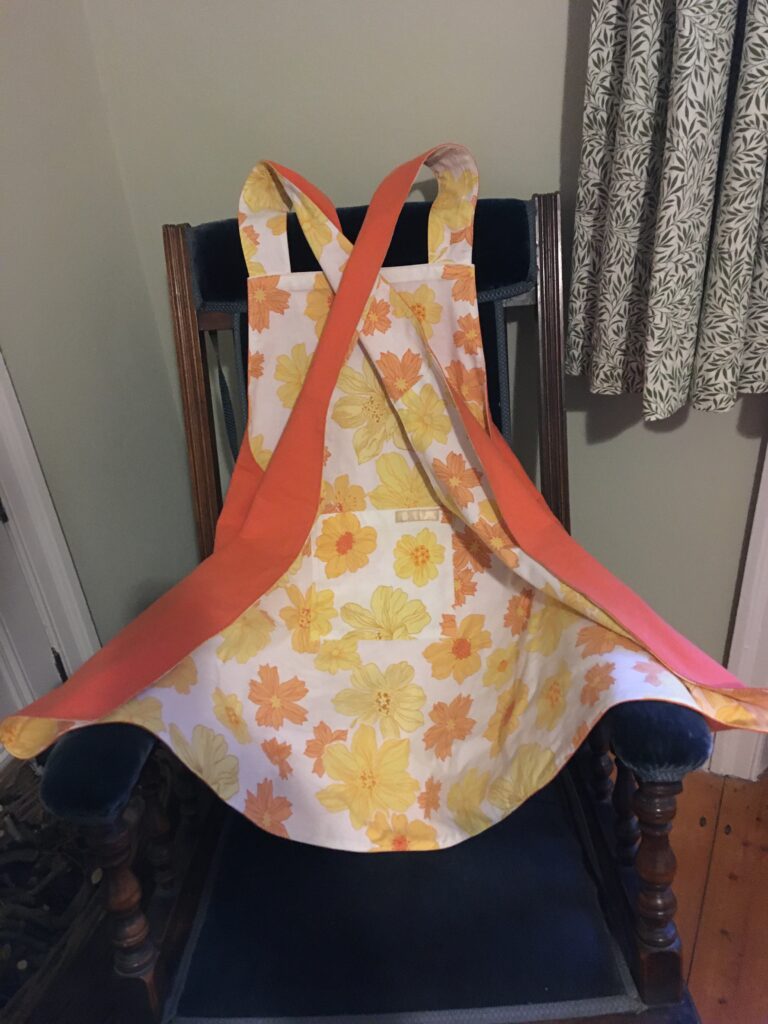 Orange & yellow floral pinny with orange cotton reverse