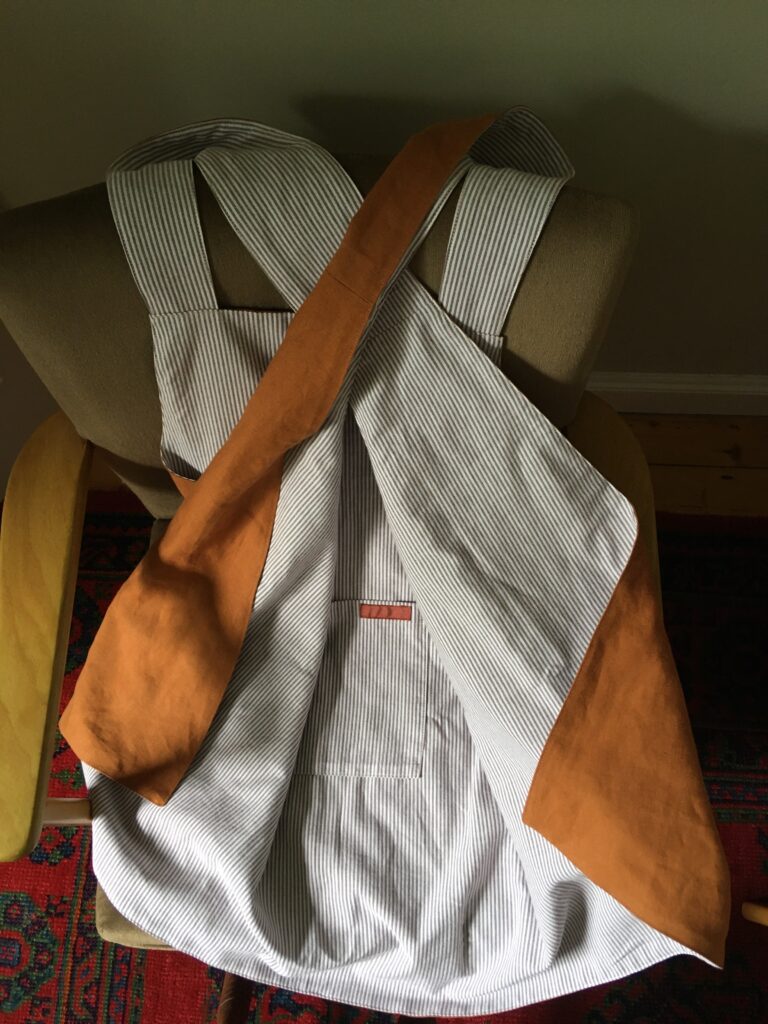 Rear view of Pinny no 177, tobacco coloured linen with pinstripe cotton on revers