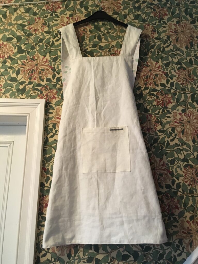 Plain cream linen reverse of single white rose pinny