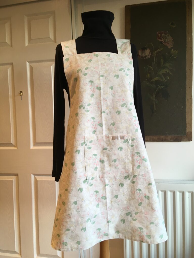 Pinny in white singe flower fabric - front view