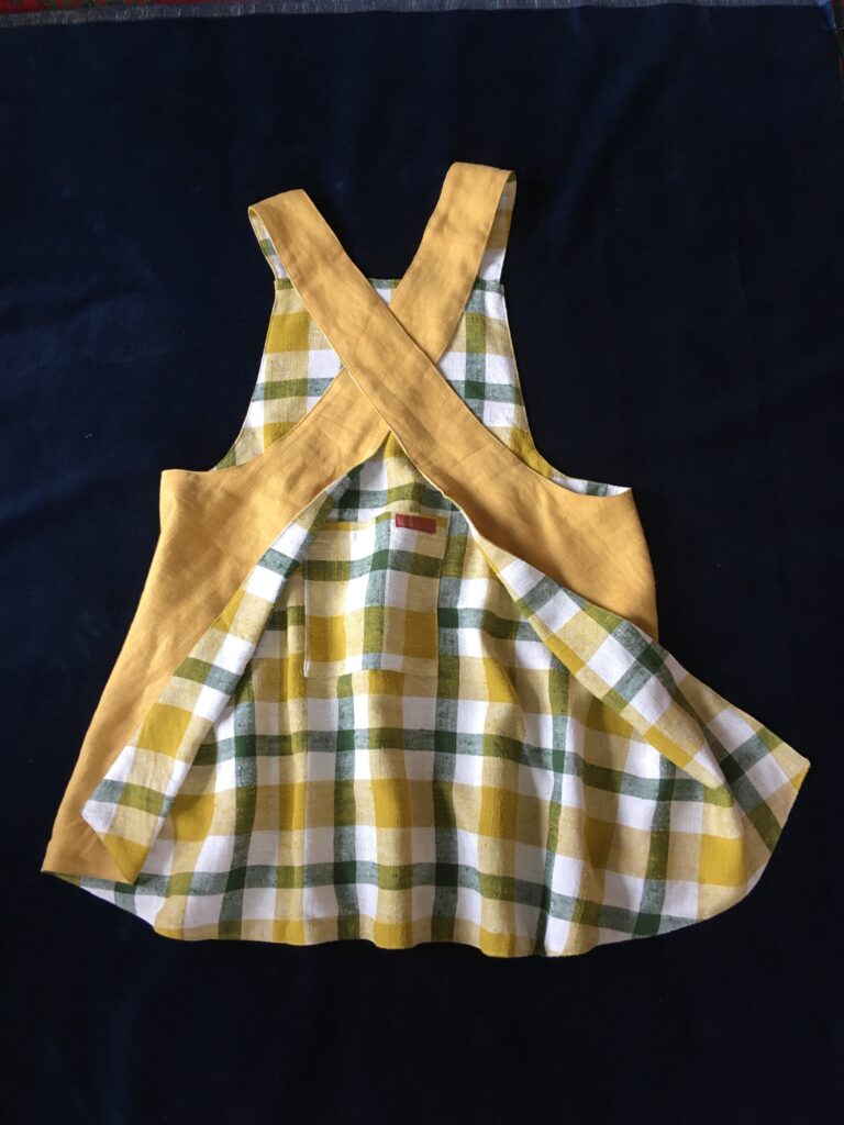 Mustard yellow linen on one side of this pinny, yellow/green/white check on other