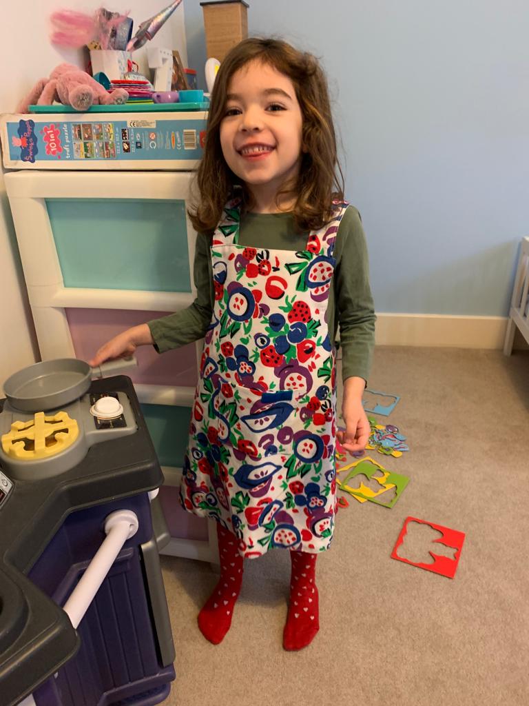 A young customer wearing her colourful apron