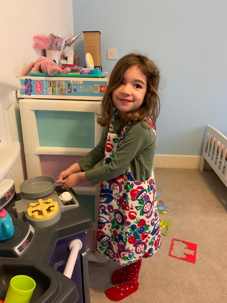 A young customer's cooking demo wearing her x-back apron